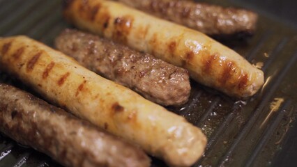 Sausages fried in a frying pan grill footage slow motion