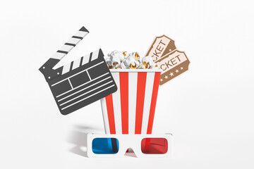 Pop corn with tickets, clapper and 3D glasses on light background