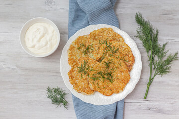 Potato pancakes with sour cream and dill.