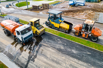Asphalt laying equipment. Asphalt paver machine on the road repair site. Road renewal process,...