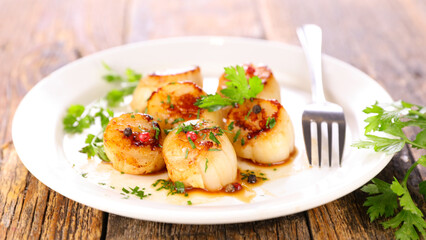 seared scallop with sauce and herbs