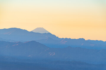 Fototapeta premium 朝焼けの富士山と山並み 長野県高峰高原より