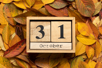 Naklejka na ściany i meble Wooden calendar with the date October 31 in autumn leaves.