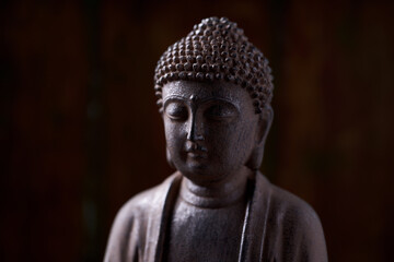Meditating Buddha Statue on dark background. Soft focus. Close up. Copy space.                                                               