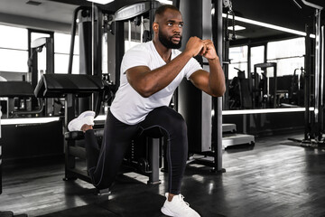 Fototapeta na wymiar Strong african sportsman doing bulgarian lunges in a gym.