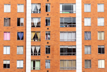Building facade with many windows and curtains. The building is made of bricks. Beautiful geometric composition, Bogota, Colombia.