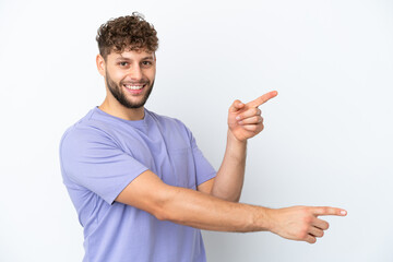 Young handsome caucasian man isolated on white background pointing finger to the side and presenting a product