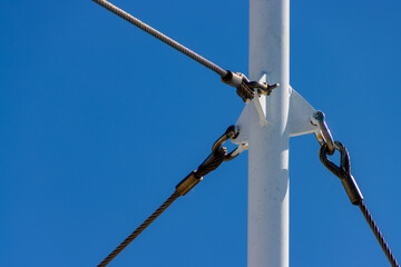 Metal pole with three steel cables attached for stability