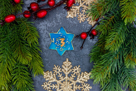 leckeres Pl&auml;tzchen mit einer Zahl (3) auf dunklem weihnachtlichen Hintergrund
