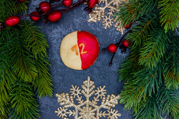 leckeres Pl&auml;tzchen mit einer Zahl (12) auf dunklem weihnachtlichen Hintergrund