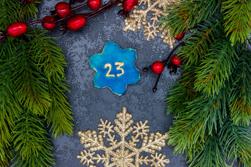 leckeres Plätzchen mit einer Zahl (23) auf dunklem weihnachtlichen Hintergrund