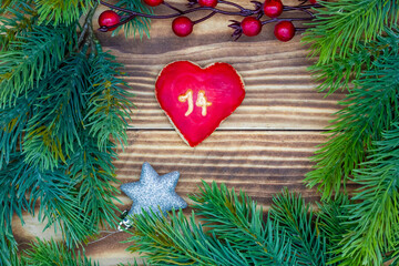 Fototapeta na wymiar leckeres Plätzchen mit einer Zahl (14) auf weihnachtlichen Hintergrund aus Holz