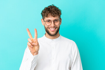 Fototapeta premium Young handsome caucasian man isolated on blue background With glasses and doing OK sign