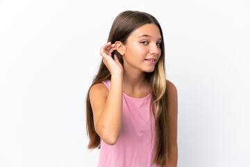 Little caucasian girl isolated on white background listening to something by putting hand on the ear