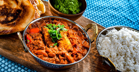 Butter chicken with rice and naan bread served in karahi pots
