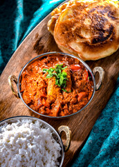 Butter chicken with rice and naan bread served in karahi pots
