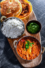 Butter chicken with rice and naan bread served in karahi pots