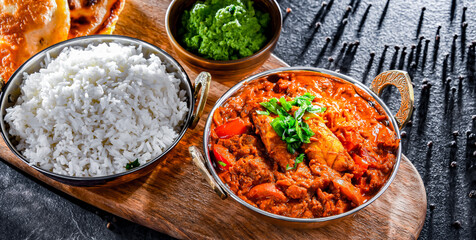 Butter chicken with rice and naan bread served in karahi pots