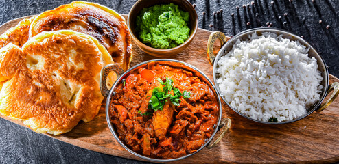 Butter chicken with rice and naan bread served in karahi pots