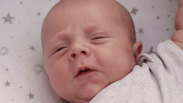 4k footage video. Close up newborn baby child lying in baby carriage stroller buggy having fun playing, looking at her mother, smiling infant. Outside walking in pushchair, fresh air
