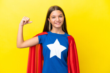 Little caucasian superhero girl isolated on yellow background doing strong gesture