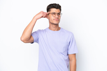 Fototapeta premium Young caucasian man isolated on white background making the gesture of madness putting finger on the head