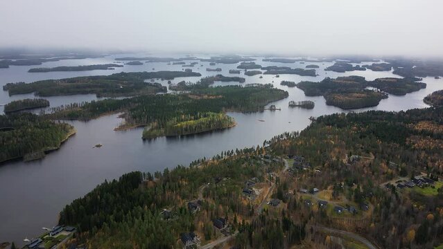 Aerial footage of lake Syväri in Finland. Several islands on a lake. Foggy sky.