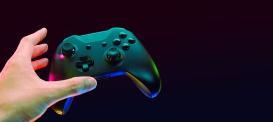 gamer playing the online game with joystick controller in neon glow dark cyberpunk room, gaming and e-sports challenge tournament streaming, streamer with analog device in living house