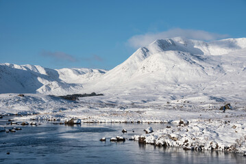Beautiful Winter landscape image looking towards Scottish Highlands mountain range across Loch Ba...