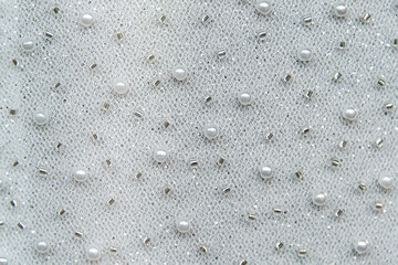 Embroidery with beads on wedding dress close up, texture. Detail of wedding lace