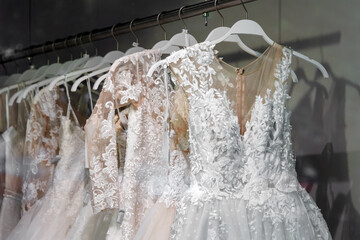 Beautiful bridal dress on hangers. Wedding dress close up at the wedding salon. Wedding dresses hanging on a hanger. Interior of bridal salon