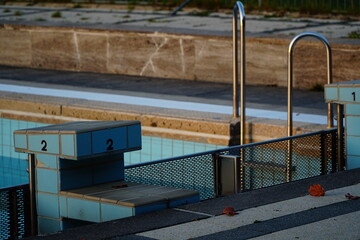 Sports swimming pool lit by the sun and starting table with a number 