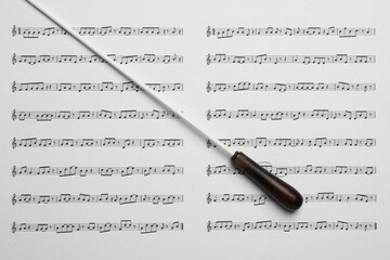 Conductor's baton on sheet music, top view - obrazy, fototapety, plakaty