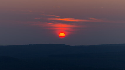 Red sunset above mountains with silhouette