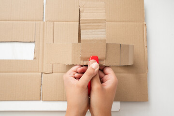 Woman's hands doing crafts putting the cardboard together with a stapler