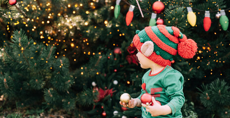 Christmas in july. children elf ears. Child waiting for Christmas in wood in july. portrait of little girl decorating christmas tree. winter holidays and people concept. Happy Holidays.