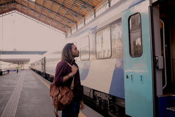 Portrait of a young man in the train station, traveling with backpack