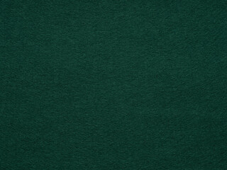 Dark green poker table felt soft rough textile material background texture close up with shade vignette. Soft pattern for text, lettering, patchworkor other art work. Full frame backdrop wallpaper.