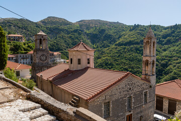 Fototapeta na wymiar Church of Taxiarches (the greatest brigadiers) and bell clock tower in Lagadia village, Arcadia, Greece