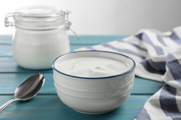 Tasty organic yogurt on light blue wooden table