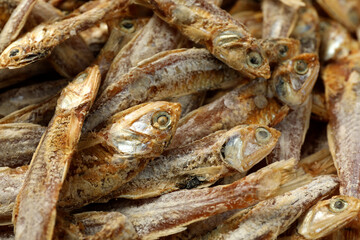 Many tasty dried anchovies as background, closeup