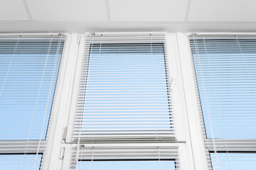 Large window with horizontal blinds indoors, low angle view