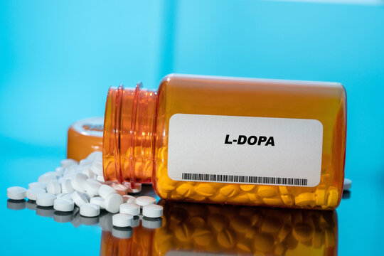 L-Dopa white medical pills and tablets spilling out of a drug bottle. Macro top down view with copy space.