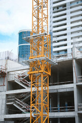 Construction site with tower crane near unfinished building