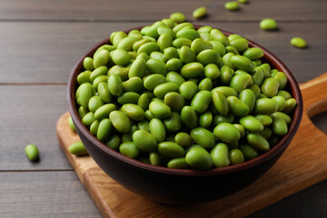 Bowl of delicious edamame beans on wooden table, closeup