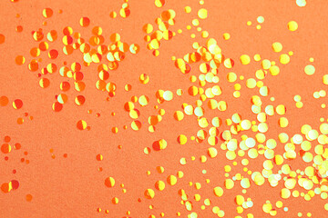 Shiny bright glitter on coral background, flat lay
