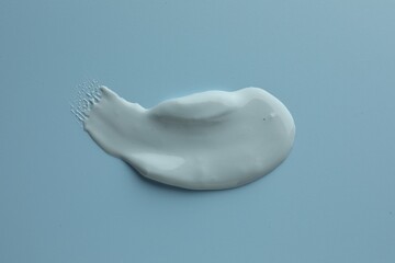 Sample of face mask on light blue background, top view