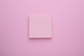 Paper note on pale pink background, top view