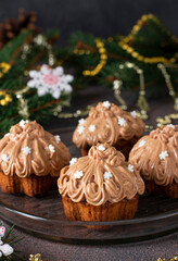 Festive homemade cupcakes with condensed milk cream on brown table