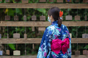 Japanese women with masks beautiful dresses Yukata Kimono and red umbrellas wear traditional...